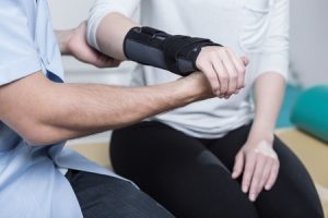 A person with an injured wrist receives treatment from a medical professional