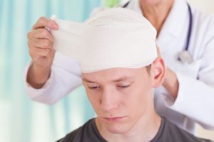 A man with a head injury receiving treatment from a doctor