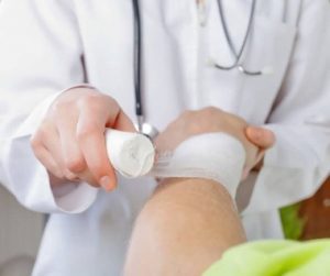 A doctor bandages a wrist.