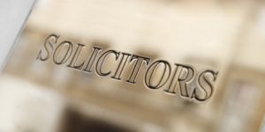 A silver plaque with the word 'solicitors' engraved on it