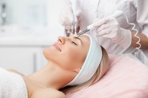 A woman receiving a facial beauty treatment.