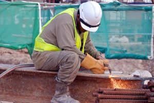 A self-employed worker using equipment on a construction site.