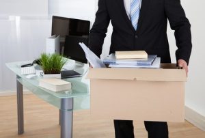 a worker with a box of his possessions leaving the office after being sacked for having an accident at work