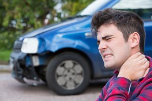 A man holds his neck following a road traffic accident. 