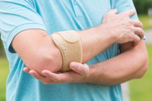 Someone holding their elbow in pain.