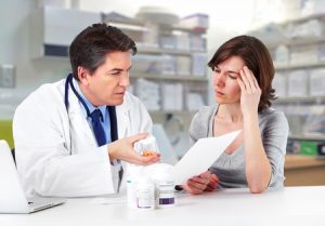 A Mansfield medical negligence professional sat with a woman looking at a medical record.
