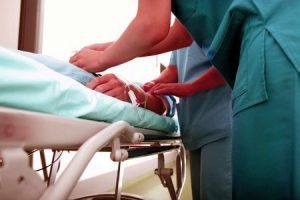 Patient with a blood clot lying on a bed and being treated by nurses