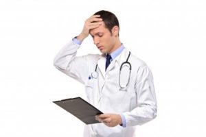 A doctor in a white coat looks at a patient chart in distress