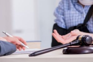 A personal injury solicitor for Hounslow talking to a client who has an arm in a sling.