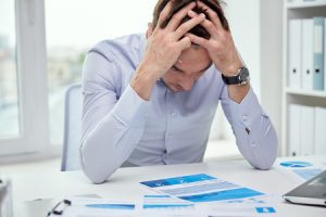 Stressed man examining a data breach report at his desk