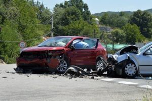 Two cars that have been smashed in a crash on the road.