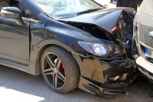 A close up of a car crashing into the back of another one, its bumper is wrecked.