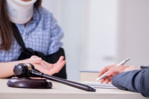 A woman wearing a neck brace discussing the seatbelt injury claims process with a solicitor.