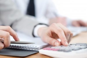 A person using a calculator to value various types of injuries in a claim. 