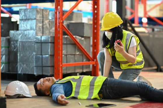 an example of a warehouse accident. an injured warehouse worker lies on the floor