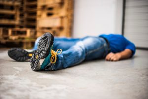 A worker laying on the floor following a workplace accident