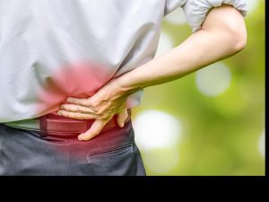 A man holding his lower back due to pain.