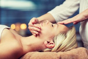 Woman receives facial massage. 