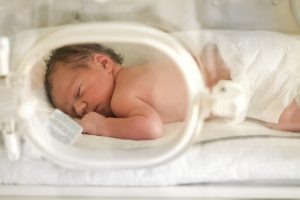 a baby laying on its stomach in an incubator