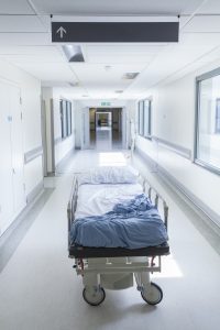 Empty bed with a drip in a hospital corridor 
