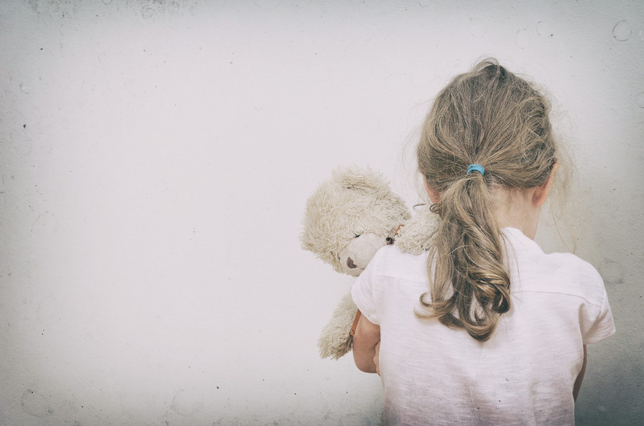 Child Sexual Abuse Victim Facing Away With Teddy Bear. 