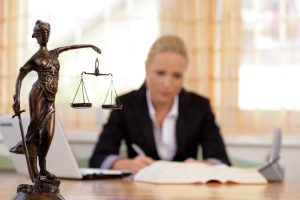 Solicitor Writes Notes At Her Desk.