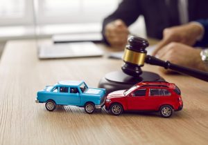 Two toy cars in front of a solicitor who can help you claim against an insurance company. 