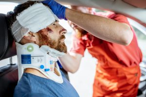 Injured Man In A Neck Brace Is Seen To By A Medic. 