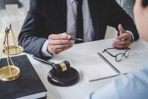 A back injury claims solicitor talks to a client at a desk