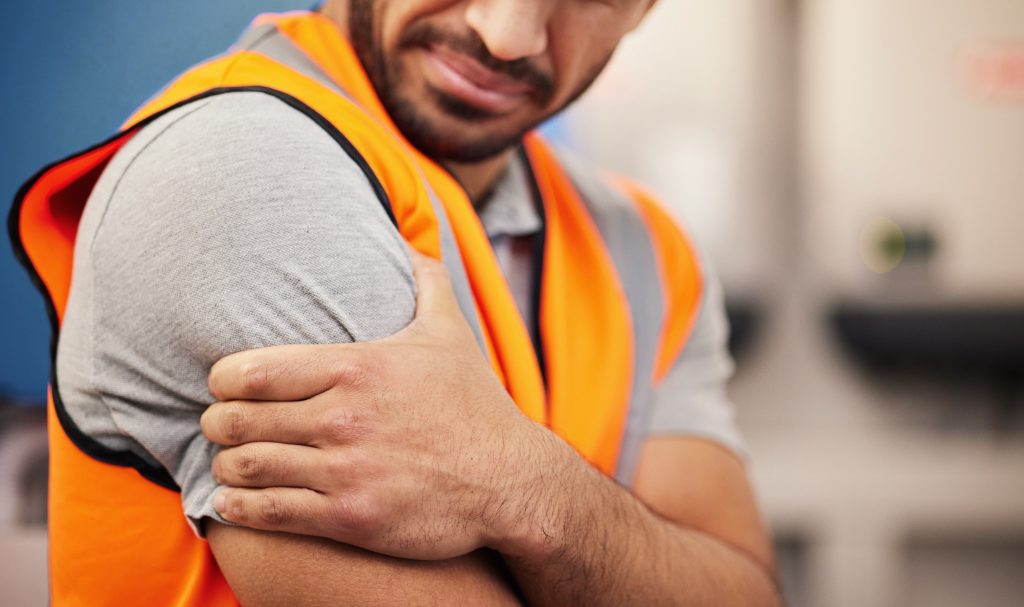 a man holding his arm after suffering a minor injury at work