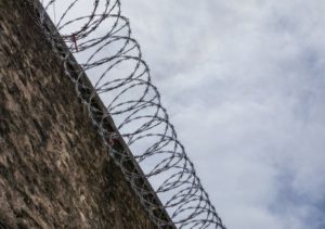 A prison wall with barbed wire on top