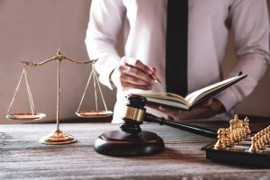 A specialist solicitor stands behind a desk taking notes in a notebook. A successful personal injury claim could help you to focus on recovery