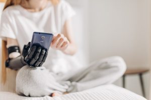 A woman with a prosthetic hand uses her phone