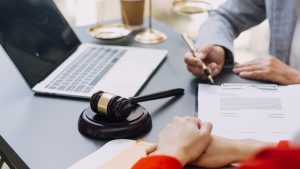 A solicitor takes notes while discussing pressure sore claims with a client. 