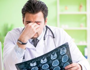 A doctor looks disappointed at an x-ray in a hospital