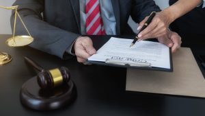 Two solicitors examining documents for morrisons accident claims in an office with a judge's gavel and justice scales