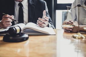 A solicitor sits at a desk taking notes while a client describes how their injuries have affected them. 