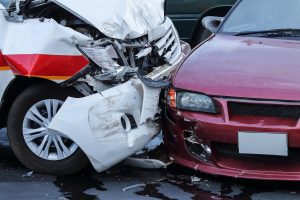 Two cars crashing causing damage to the bonnets
