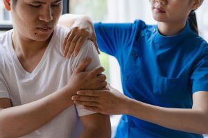 A male receives physiotherapy treatment on his shoulder