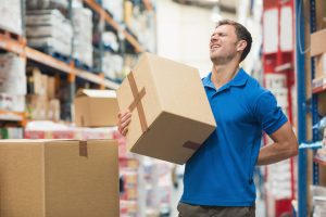 A worker experiences back pain whilst carrying heavy boxes