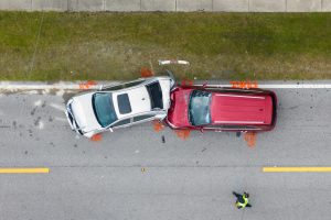 An overhead shot of a serious car crash involving red car and a white car