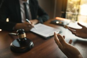A solicitor being asked by their client, "who pays for work related injuries?" during a meeting
