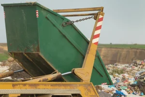 Rubbish being tipped out of a green skip