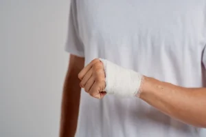 A close-up of a man with a bandaged hand