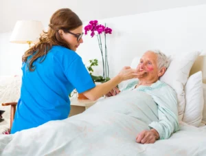 A nursing home patient is cared for while propped up in bed.