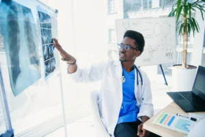 A doctor in a white lab coat discussing a patient's scans during a meeting