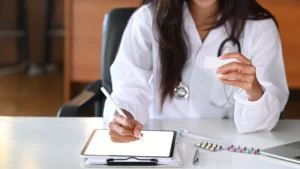 A GP is taking notes about her patient