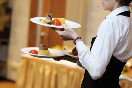 waiting staff carrying dishes to a table