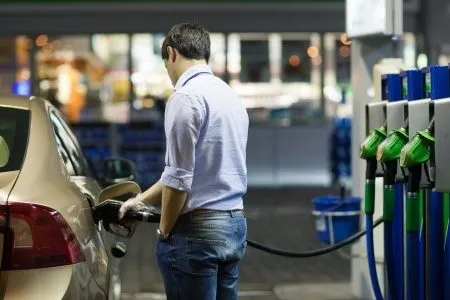 a man filling up his car at a petrol station